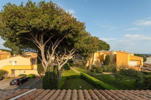 une vue d'une maison avec un arbre et une voiture dans l'établissement Evasion Marine, au Cap d'Agde