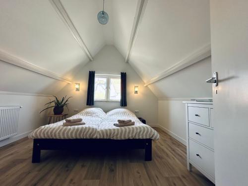 a bedroom with a bed in a attic at Havenhuis TEXEL, per week or weeks Saturday-Saturday in Oudeschild