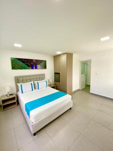 a large bedroom with a large bed and a tv at Hotel Villa Mónaco in Pereira