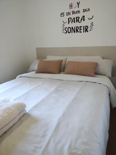 a large white bed with a sign on the wall at Tudela in Tudela