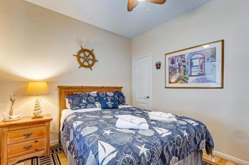 a bedroom with a bed with a blue and white bedspread at SharkyFins II in Gilchrist