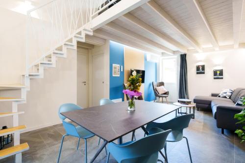 a dining room with a table and blue chairs at La Casa Incartata in Toscolano Maderno