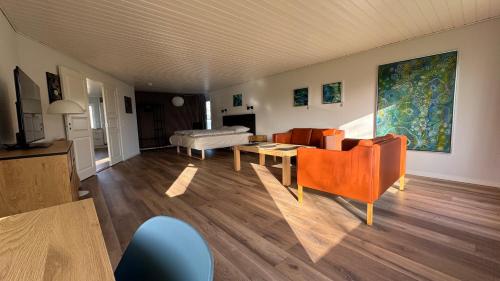 ein Wohnzimmer mit orangefarbenen Stühlen und einem Sofa in der Unterkunft Guest Home Oksbøl in Oksbøl