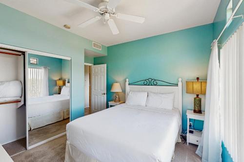 une chambre avec un lit blanc et un mur bleu dans l'établissement Vistoso Resort Casitas 235, Building 12, à Oro Valley