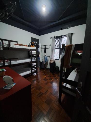 a room with bunk beds and a room with a table at Youkoso Hostel in Florianópolis
