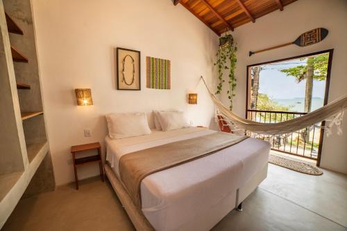 a bedroom with a bed and a large window at Casa Canoa Paraty in Paraty