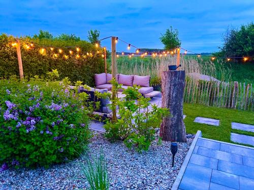 a garden with a couch and some flowers and lights at Premium-Strand Chalet an der Nordsee - Noordzee - Zeeland in Breskens