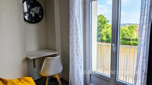 Cette chambre dispose d'une fenêtre, d'une chaise et d'un réveil. dans l'établissement La Tanière de Saint Jacques, à Redon