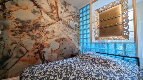 a bedroom with a bed and a wall at La Tanière de Saint Jacques in Redon