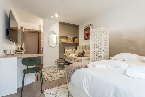 Cet appartement comprend une chambre avec un lit blanc et une cuisine. dans l'établissement Beautiful Studio le Kennedy Mulhouse Downtown 3 pers, à Mulhouse