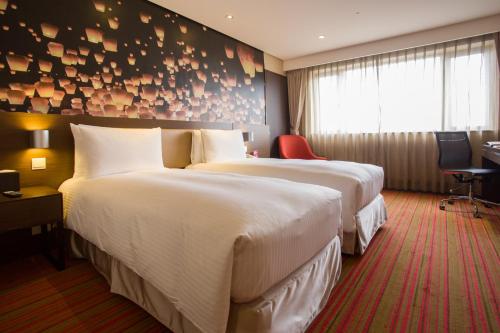 Postel nebo postele na pokoji v ubytování Tao Garden Hotel