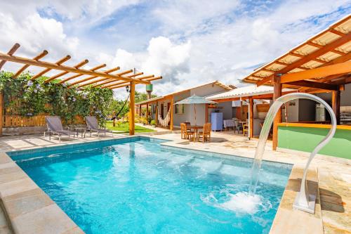 a swimming pool with a water fountain at Espaço inteiro:piscina aquecimento solar,2 suítes in Pirenópolis