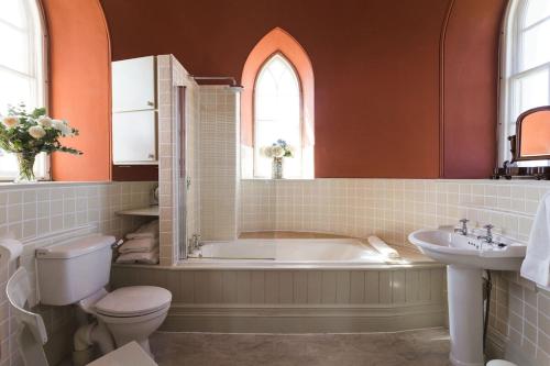 a bathroom with a tub and a toilet and a sink at Haldon Belvedere Lawrence Castle in Halton