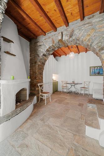 a living room with a stone fireplace and a table at Sea view house , for 5 persons in Triandaros in Triandáros