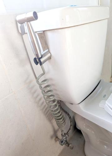 a white toilet with a hose attached to it at Epic Views - 7 min from airport in Bajos de Chila