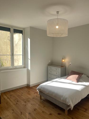 a white bedroom with a bed and a window at La Villa Chorier in Grenoble