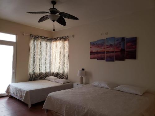 a bedroom with two beds and a ceiling fan at Casa Coral in San José de Guatemala