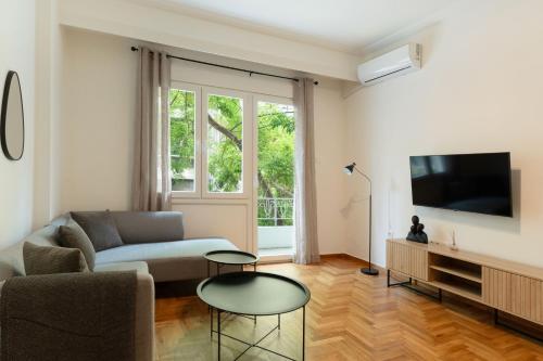 a living room with a couch and a tv at Athens Ivy Residence By Staycom in Athens