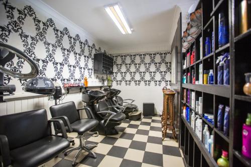 a hair salon with black chairs and a checkered floor at The Shady Rest Hotel in Port Moresby
