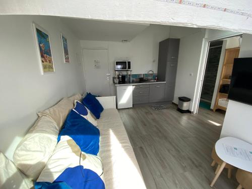 un salon avec un canapé et une cuisine dans l'établissement Charmant petit appartement vue mer et corniche Esterel, à Anthéor