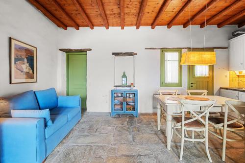 a living room with a blue couch and a table at Sea view house , for 5 persons in Triandaros in Triandáros