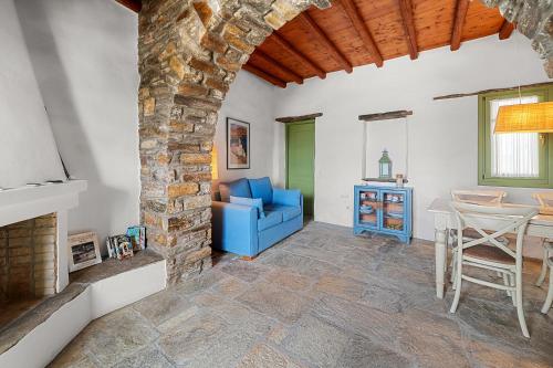 a living room with a stone fireplace and a blue couch at Sea view house , for 5 persons in Triandaros in Triandáros