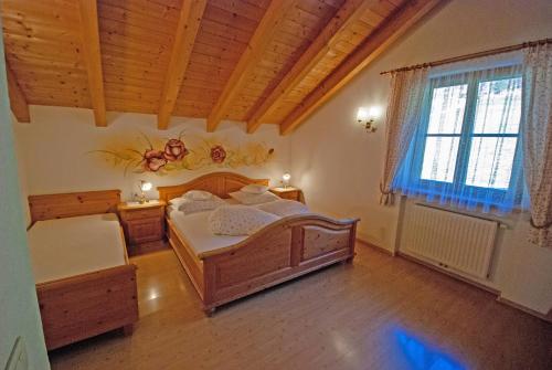 a bedroom with two beds and a wooden ceiling at Im Kranzhof in San Candido