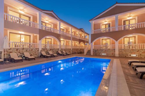 a hotel with a swimming pool in front of a building at Zante Holidays Hotel in Kalamaki
