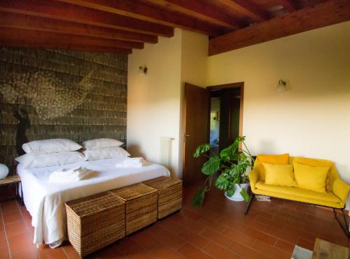 a bedroom with a bed and a yellow chair at Alice nel Paese delle Meraviglie in Gavardo