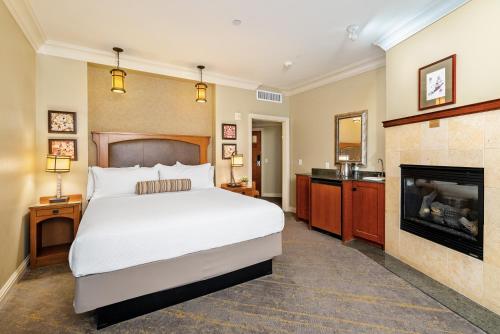 a bedroom with a large bed and a fireplace at Avila Village Inn in Avila Beach