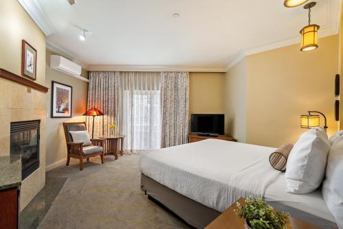 a hotel room with a bed and a television at Avila Village Inn in Avila Beach