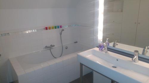 a bathroom with a shower and a sink and a tub at Family holiday home - very close to sandy beach in Gorey