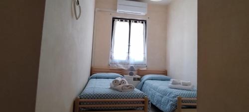 a small room with two beds and a window at Casa Clelia in Pula