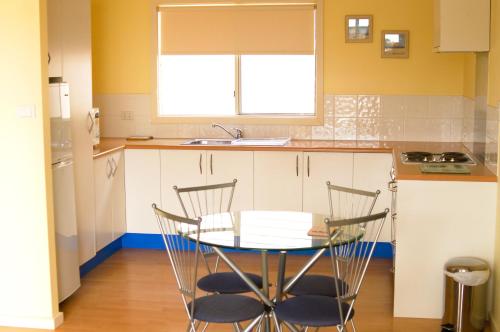 een keuken met een tafel en stoelen en een wastafel bij Lindsays of Kangaroo Island in Penneshaw
