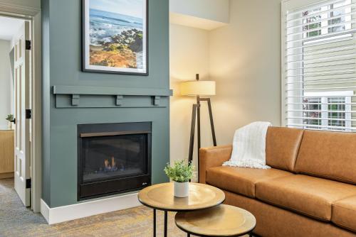 a living room with a couch and a fireplace at Avila Village Inn in Avila Beach