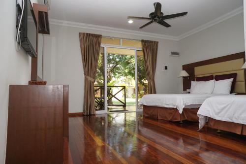 1 dormitorio con 2 camas y ventilador de techo en Langkah Syabas Beach Resort, en Kinarut