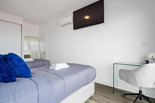 a bedroom with a bed with a chair and a mirror at Villa Vellure by Homie in Funchal