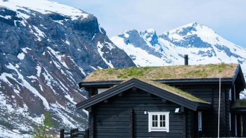 une cabane en rondins avec une montagne enneigée en arrière-plan dans l'établissement Appartement Gujan-Mestras, à Gujan-Mestras