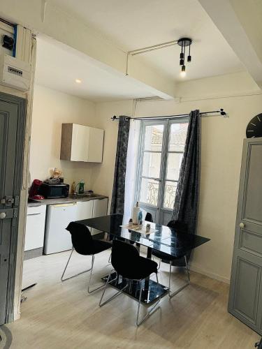 une cuisine avec une table et des chaises et une fenêtre dans l'établissement Charmant T2 tout confort centre ville BEZIERS, à Béziers