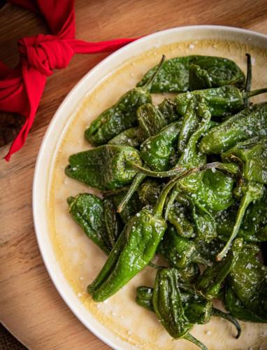 a bowl of green peppers on a table at Cit'Hôtel Beausoleil DAX in Dax