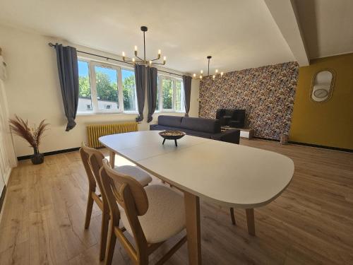 a living room with a white table and chairs at L'Arena - Le Woody in Liévin