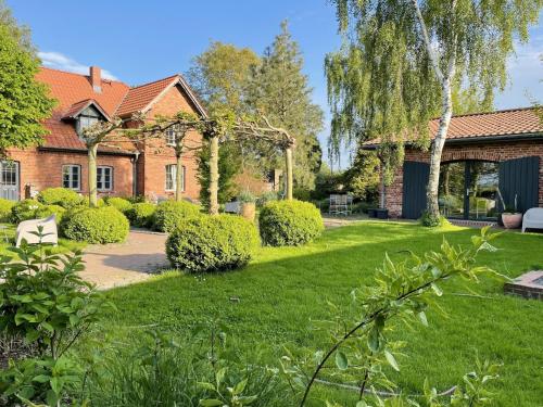 ein Haus mit einem grünen Hof mit einem Weg in der Unterkunft Idyllischer Hof mit 5 Wohnungen nahe des Saaler Boddens in Saal