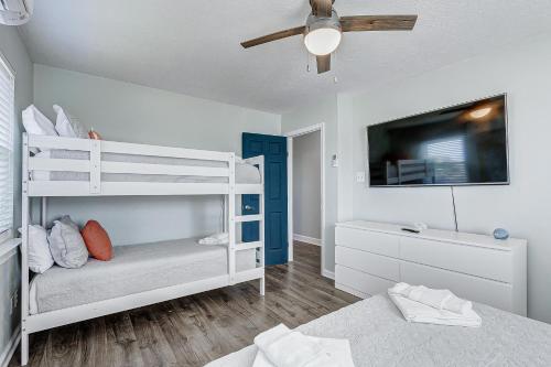 a bedroom with two bunk beds and a ceiling fan at The Showboat in Crystal Beach