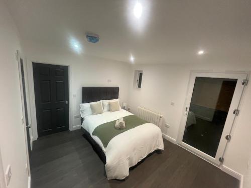 a bedroom with a bed with a cat sitting on it at The Stables in Hatfield