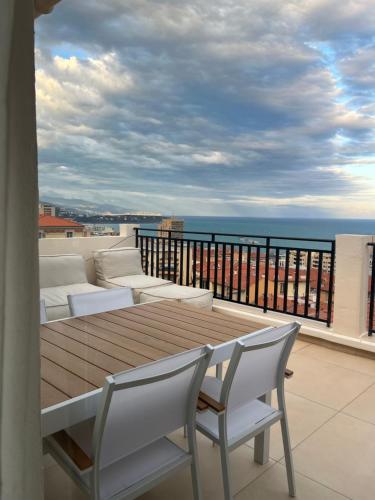 a table and chairs on a balcony with a view of the ocean at Beaunaco - Wellness Penthouse in Beausoleil