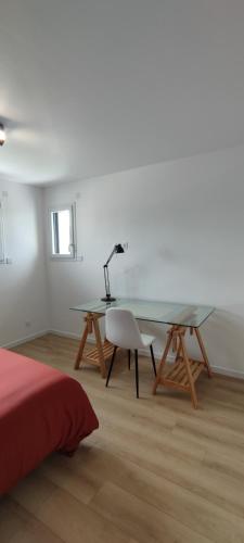a bedroom with a desk and a table and a bed at Ti vakansin war aod an emrodez in Ruca