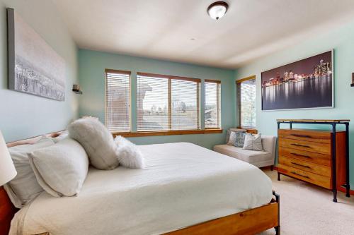 a bedroom with a bed and a dresser and windows at Truckee Living in Truckee