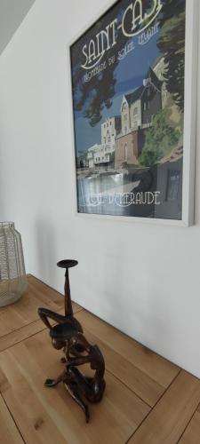 a chair sitting on a wooden floor in front of a poster at Ti vakansin war aod an emrodez in Ruca