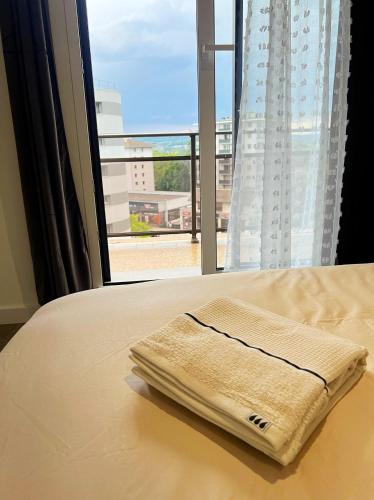 - une serviette sur un lit en face d'une fenêtre dans l'établissement Annecy Naila's apartement, à Annecy