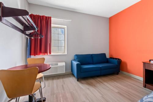 a living room with a blue couch and a table at Scottish Inns & Suites - North Hershey in Harrisburg